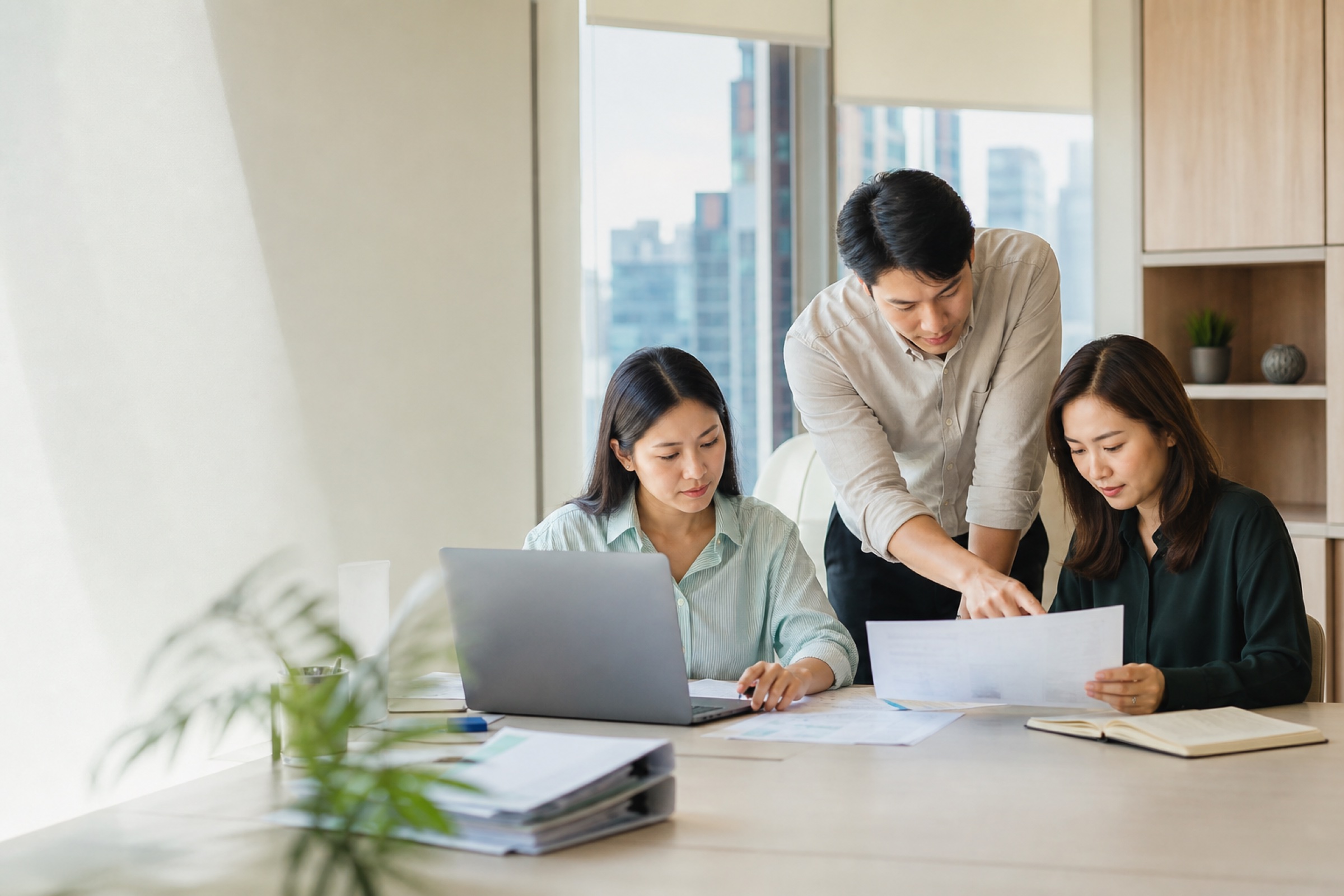 A finance and operations team reviewing documents and records together
